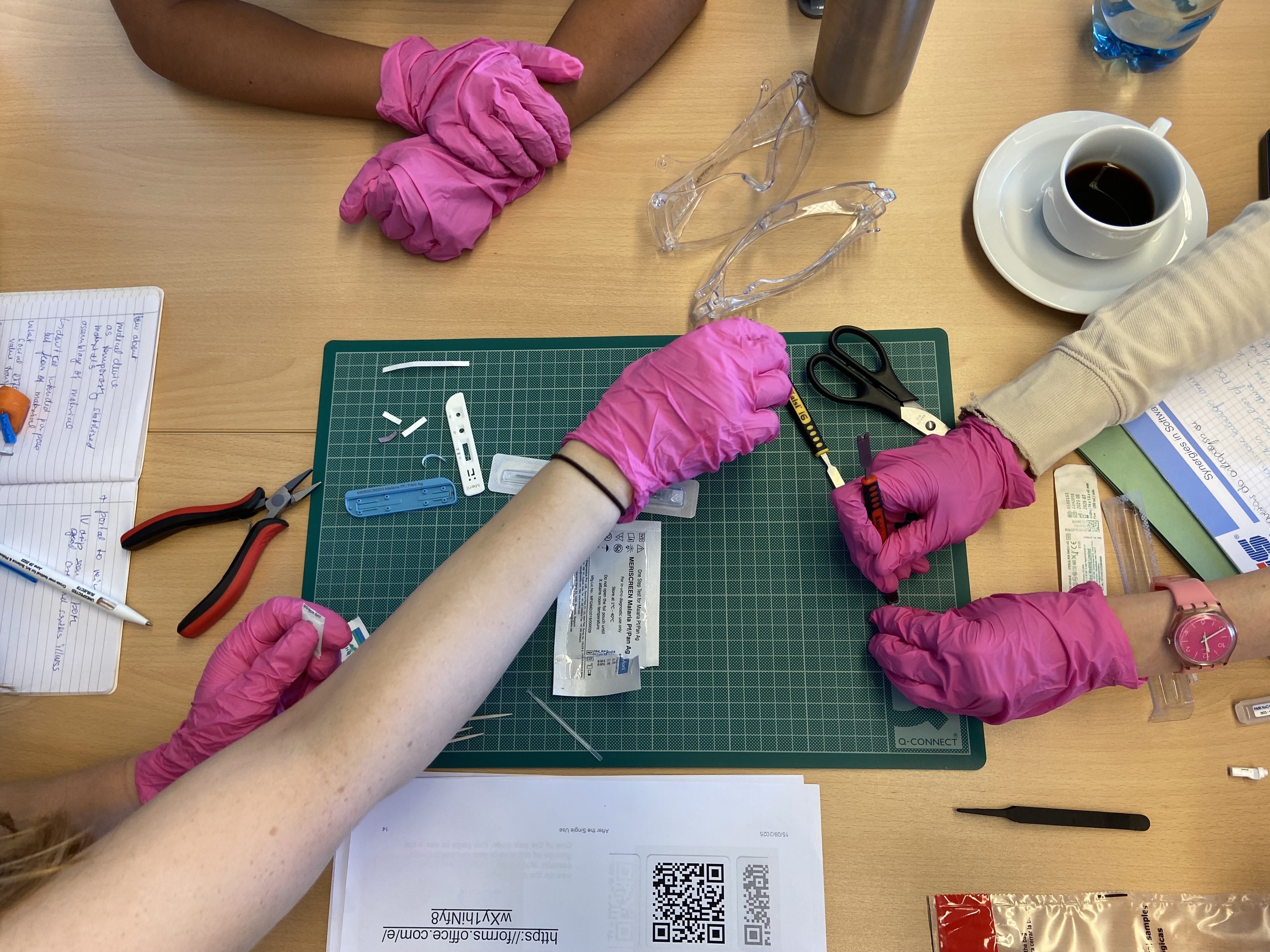 Hands wearing gloves are taking apart medical devices.