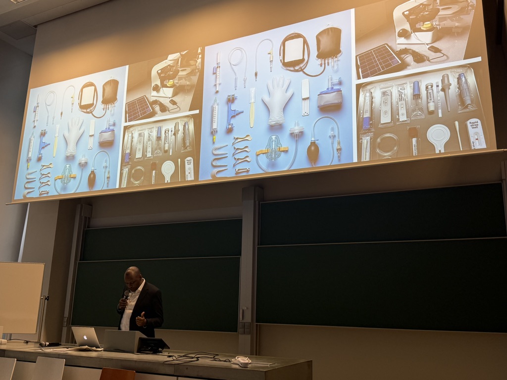 Peter presenting his paper with images of single-use devices on the screen behind him