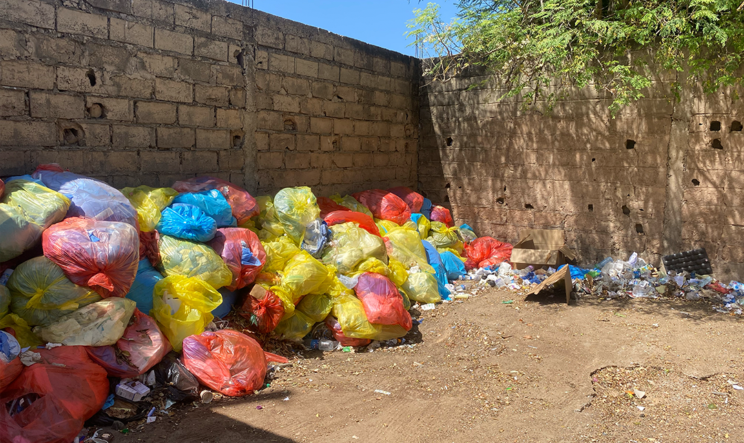 Various medical waste bags are stacked against a wall at Fann Hospital in Dakar, Senegal.