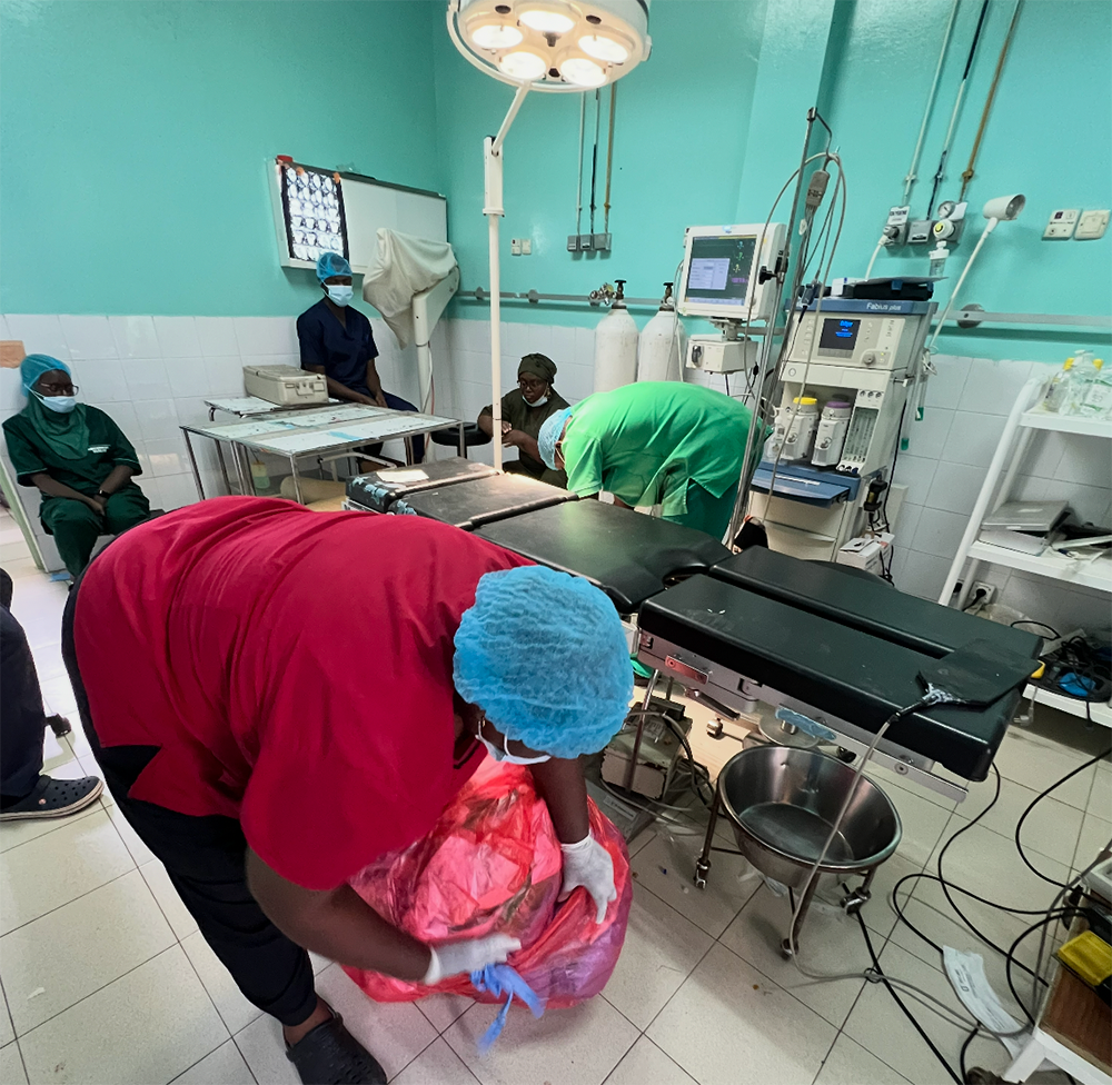 Hospital workers in Fann Hospital cleaning up a theatre in scrubs. 