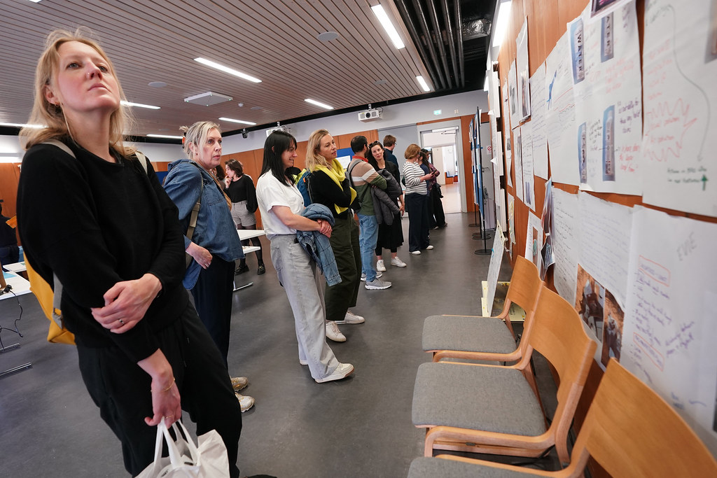 Exhibition attendees reflect on documents outlining what collaboration means for this project.