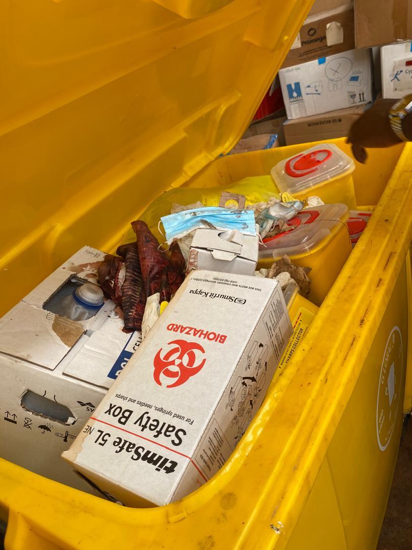 Yellow bin of untreated biomedical waste stored on site.