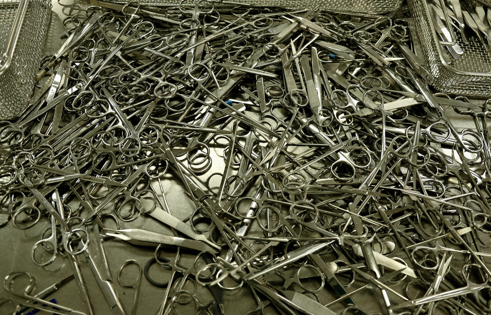 Large pile of scissors on chrome table. 