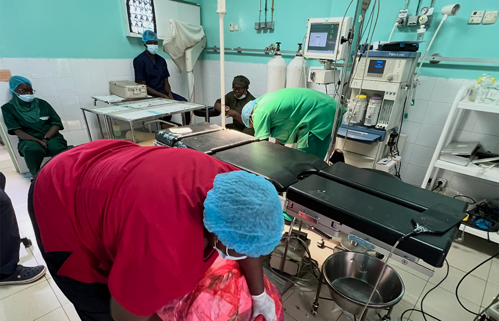 Hospital workers in Fann Hospital cleaning up a theatre in scrubs. 